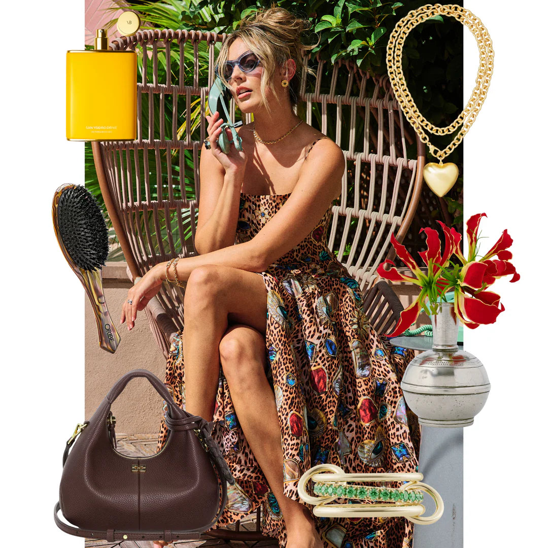 Woman in leopard print dress sitting on a chair with various fashion items displayed around her.